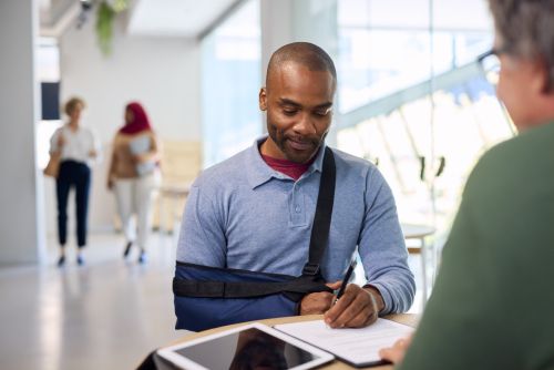 Injured man signs for compensation with his insurance agent